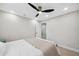 Bright bedroom featuring a queen-sized bed, bedside tables, light floors, trim, modern ceiling fan, and ensuite entrance at 205 W Wheeler Rd, Seffner, FL 33584