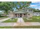 Inviting two-story home with a charming covered front porch, landscaped yard, and an American flag at 205 W Wheeler Rd, Seffner, FL 33584