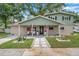 Inviting two-story home with a charming covered front porch, landscaped yard, and an American flag at 205 W Wheeler Rd, Seffner, FL 33584