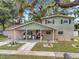 Charming two-story home featuring a covered front porch with rocking chairs and welcoming curb appeal at 205 W Wheeler Rd, Seffner, FL 33584