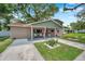 Charming two-story home featuring a covered front porch with rocking chairs and inviting landscaping at 205 W Wheeler Rd, Seffner, FL 33584