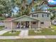 Charming two-story home featuring a covered front porch with rocking chairs and welcoming curb appeal at 205 W Wheeler Rd, Seffner, FL 33584