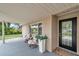 Charming front porch with seating area, potted plants, and a view of the landscaped front yard at 205 W Wheeler Rd, Seffner, FL 33584