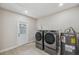 Laundry room features modern washer and dryer plus a water heater and access to the exterior at 205 W Wheeler Rd, Seffner, FL 33584