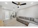 Open concept living room featuring a modern ceiling fan, stylish floors, couch, and an entryway to the bathroom at 205 W Wheeler Rd, Seffner, FL 33584