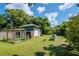View of backyard featuring the shed, garden beds, and lush green space at 211 Arlington E Ave, Oldsmar, FL 34677