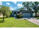 Charming single-story home featuring a well-manicured lawn, attached garage, and inviting front entrance at 211 Arlington E Ave, Oldsmar, FL 34677