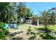 Landscaped backyard with a screened-in porch, mature trees and a seating area at 23924 Forest Pl, Land O Lakes, FL 34639