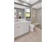 Bathroom featuring a modern vanity with a large mirror, walk-in shower with glass door and neutral tile at 23924 Forest Pl, Land O Lakes, FL 34639
