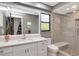 Bathroom featuring a modern vanity with a large mirror, walk-in shower with glass door and neutral tile at 23924 Forest Pl, Land O Lakes, FL 34639