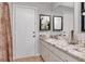 Bathroom with white cabinets, granite counters, and a large mirror at 23924 Forest Pl, Land O Lakes, FL 34639