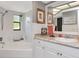 Bathroom featuring a soaking tub and vanity with granite countertop and framed mirror at 23924 Forest Pl, Land O Lakes, FL 34639