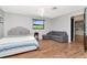 Well-lit bedroom with hardwood floors, comfortable furniture, and view to the kitchen at 23924 Forest Pl, Land O Lakes, FL 34639