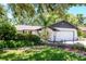 Charming home with a well-manicured lawn, a two car garage, and wrought iron gated courtyard at 23924 Forest Pl, Land O Lakes, FL 34639