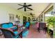 Screened lanai featuring turquoise patio furniture, a hammock and brick flooring with outdoor view at 23924 Forest Pl, Land O Lakes, FL 34639