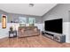 Cozy living room with a comfortable couch, wood flooring, and a large flat screen television at 23924 Forest Pl, Land O Lakes, FL 34639