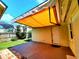 Backyard patio with an awning features well-manicured landscaping at 2645 Woodring Dr, Clearwater, FL 33759