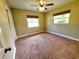 This bedroom offers a ceiling fan, two windows, and neutral carpeting at 2645 Woodring Dr, Clearwater, FL 33759