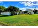 Expansive lawn with mature trees surrounds this home, partially enclosed by a privacy fence at 2645 Woodring Dr, Clearwater, FL 33759
