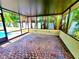 Relax in this covered patio featuring brick pavers and views of lush landscaping at 2645 Woodring Dr, Clearwater, FL 33759