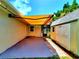 View of the patio showing the awning, outdoor storage, and view of the screened in pool area at 2645 Woodring Dr, Clearwater, FL 33759