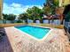 A backyard pool features steps, handrail, brick surround, and tropical landscaping at 2645 Woodring Dr, Clearwater, FL 33759