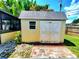 Charming backyard shed featuring double doors, a window, and brick pavers at 2645 Woodring Dr, Clearwater, FL 33759