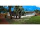 Large screened in porch overlooking a spacious backyard lined with mature palm trees at 2837 Woodcrest Dr, Sarasota, FL 34239
