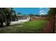 An open backyard area with an extended screened in patio area and manicured shrubbery at 2837 Woodcrest Dr, Sarasota, FL 34239