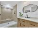 Bathroom featuring a glass shower, wooden vanity, quartz countertop, modern fixtures and a unique mirror at 2837 Woodcrest Dr, Sarasota, FL 34239