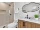 Bathroom featuring a glass shower, wooden vanity, quartz countertop, modern fixtures and a unique mirror at 2837 Woodcrest Dr, Sarasota, FL 34239