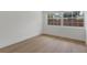 Cozy bedroom highlighting the light hardwood floors, white walls, base molding, and a view to the backyard at 2837 Woodcrest Dr, Sarasota, FL 34239