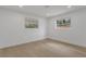 Cozy bedroom highlighting the light hardwood floors, white walls, base molding, and a view to the backyard at 2837 Woodcrest Dr, Sarasota, FL 34239