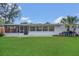 A view of the home's exterior features a well-maintained lawn and screened-in porch at 2837 Woodcrest Dr, Sarasota, FL 34239
