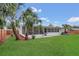 An exterior view of the home highlights the screened-in porch and expansive, well-maintained backyard at 2837 Woodcrest Dr, Sarasota, FL 34239