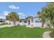 Charming home featuring lush green lawn, palm trees, and freshly painted white exterior at 2837 Woodcrest Dr, Sarasota, FL 34239