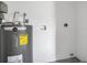 Utility Room featuring the hot water heater and connections for the laundry, with white walls and painted floors at 2837 Woodcrest Dr, Sarasota, FL 34239