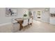 Bright dining area with sliding glass doors to the patio, wooden table, upholstered chairs, and view into the kitchen at 2905 Forest Cir, Seffner, FL 33584