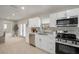Modern kitchen with stainless steel appliances, white cabinets, tiled backsplash, and a view into the dining area at 2905 Forest Cir, Seffner, FL 33584