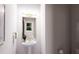 Stylish powder room featuring a pedestal sink, modern lighting, and a gold-framed mirror at 3005 1St N Ave, St Petersburg, FL 33713