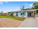 Charming single-story home showcasing blue shutters, a well-manicured lawn, and a brick driveway at 3015 Florida Blvd, Bradenton, FL 34207