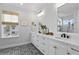 Bright bathroom showcasing a double vanity with white countertops, stylish tile flooring, and modern fixtures at 303 N Beverly Ave, Tampa, FL 33609
