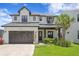 Charming two-story home features a landscaped yard, a garage, and a welcoming front porch at 303 N Beverly Ave, Tampa, FL 33609