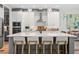 Modern kitchen features an island with seating, white cabinets, and stainless steel appliances at 303 N Beverly Ave, Tampa, FL 33609
