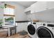Bright laundry room with modern washer and dryer, sink, and plenty of counter space at 303 N Beverly Ave, Tampa, FL 33609