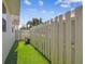Private backyard featuring artificial turf and a stylish white fence, perfect for outdoor relaxation at 3100 W Paul Ave # 15, Tampa, FL 33611