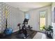Bright exercise room with modern equipment, geometric wallpaper and an exterior door at 3100 W Paul Ave # 15, Tampa, FL 33611