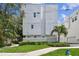 Shot of the exterior showcasing a grassy front yard with a modern townhouse in the background at 3100 W Paul Ave # 15, Tampa, FL 33611