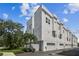 Exterior view of modern townhomes with white facades and attached garages under a bright sky at 3100 W Paul Ave # 15, Tampa, FL 33611