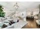 Open-concept living space featuring hardwood floors, modern lighting, and a stylish kitchen in the background at 3100 W Paul Ave # 15, Tampa, FL 33611